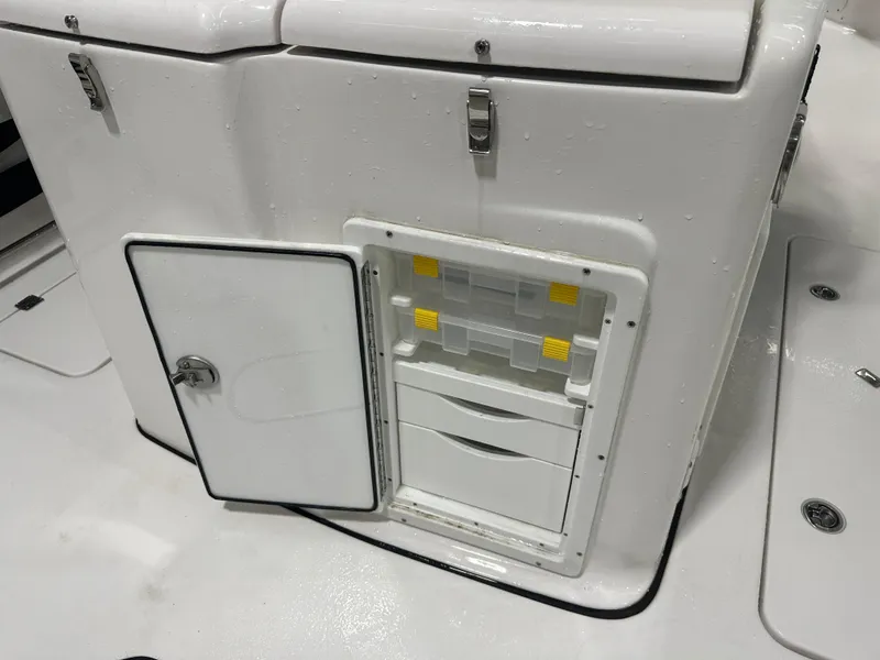 Slide: The Image of 2024 Tidewater 292CC boat storage compartment with drawers and latch. - 26
