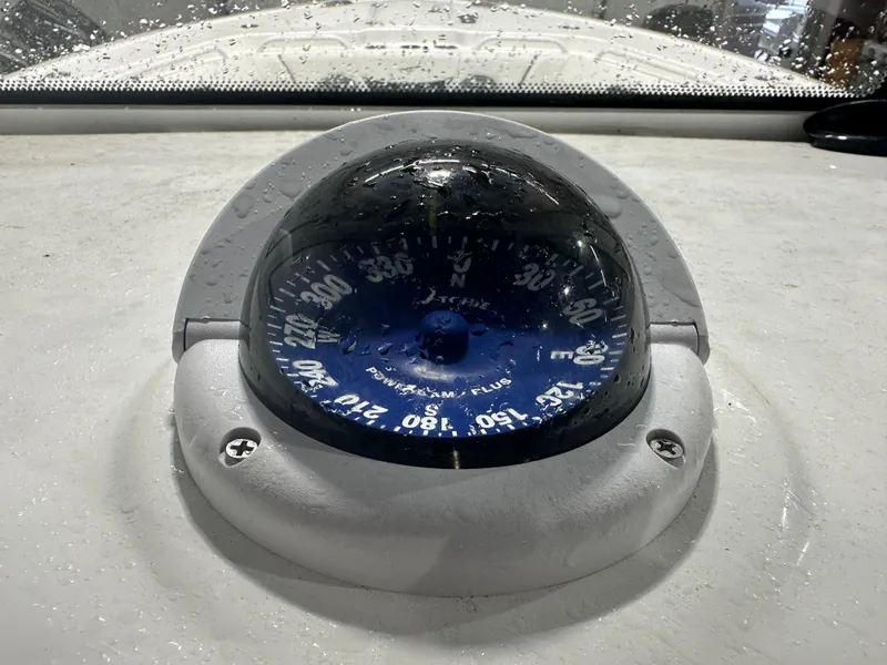 Slide: The Image of Compass on 2024 Tidewater 292CC boat, wet with raindrops. - 36