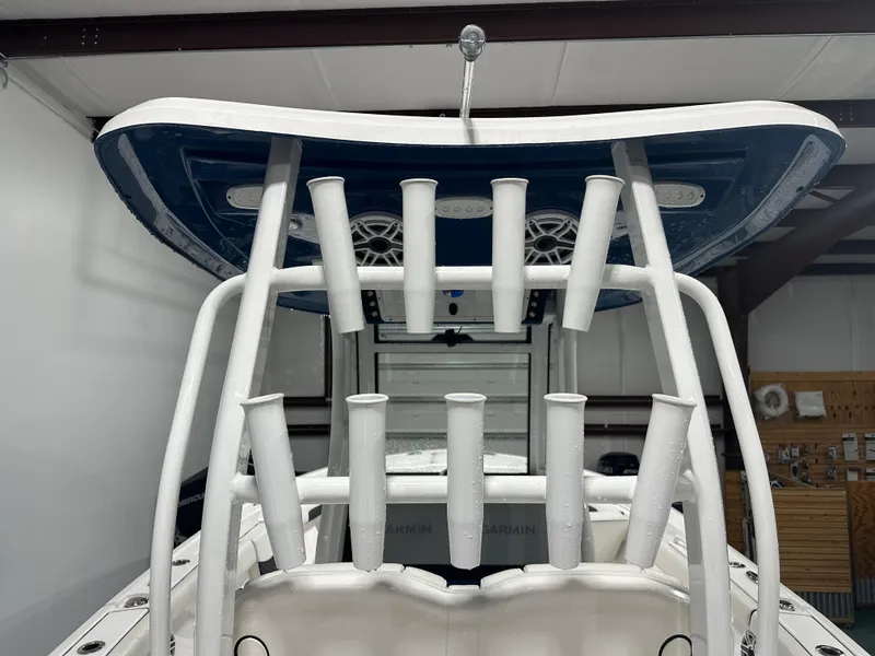 Slide: The Image of 2024 Tidewater 292CC boat with rod holders and T-top in a garage. - 40