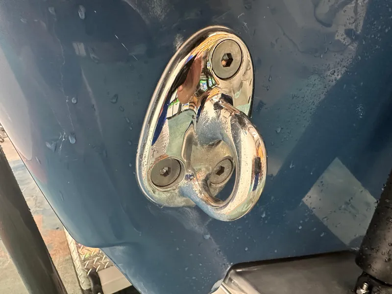 Slide: The Image of Close-up of a 2024 Tidewater 292CC boat's metal cleat on a wet blue surface. - 8