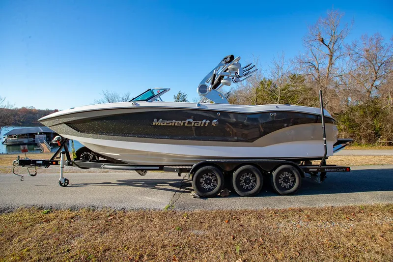 Slide: The Image of 2019 MasterCraft X24 boat on trailer, parked outdoors on a sunny day. - 1