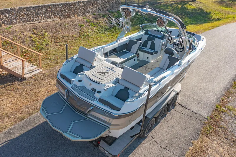 Slide: The Image of 2019 MasterCraft X24 boat on trailer, rear view, outdoor setting. - 10