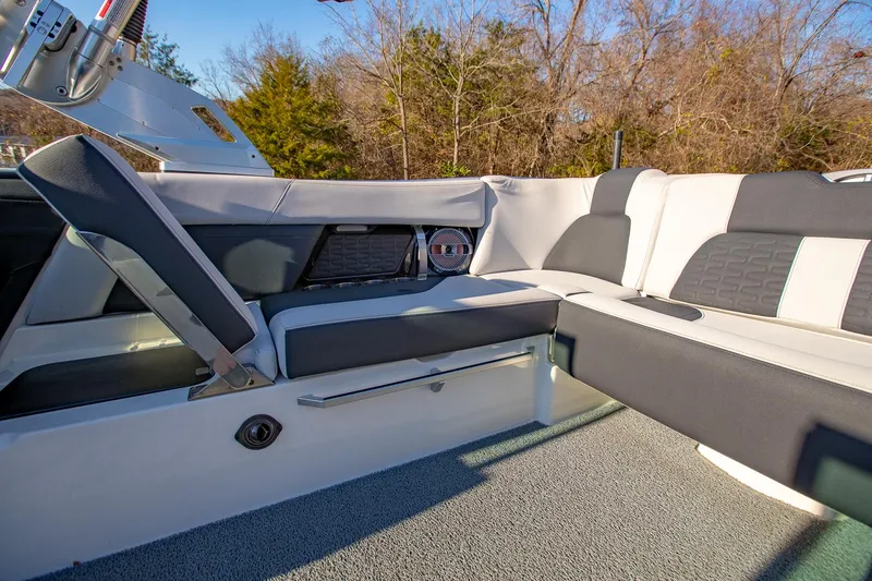 Slide: The Image of 2019 MasterCraft X24 boat interior with gray and white seating, outdoor setting. - 18