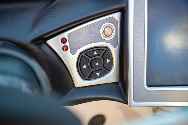 Slide: The Image of Close-up of 2019 MasterCraft X24 boat control panel with buttons and screen. - 24