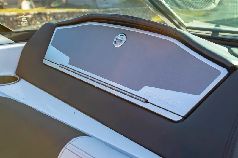 Slide: The Image of 2019 MasterCraft X24 boat dashboard with sleek design and storage compartment. - 31