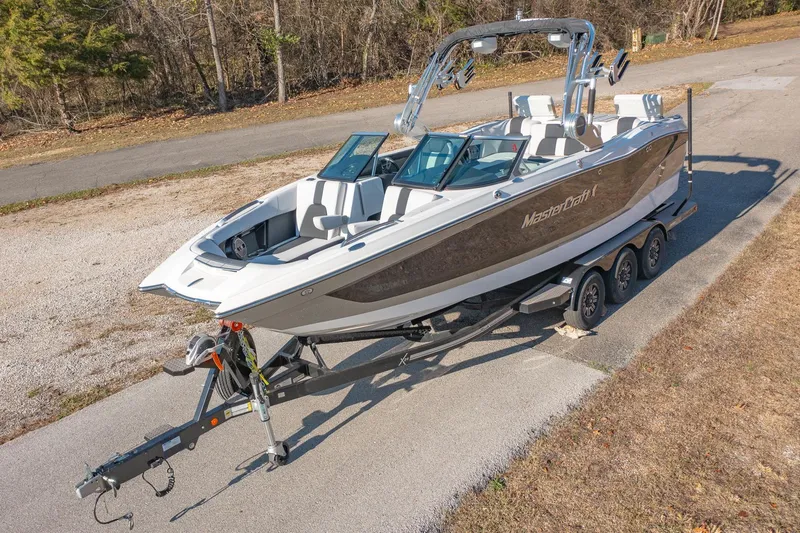 Slide: The Image of 2019 MasterCraft X24 boat on trailer, parked on a paved road. - 9