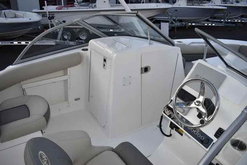 Slide: The Image of 2025 Key West 239 DFS boat interior with steering wheel and seating. - 13