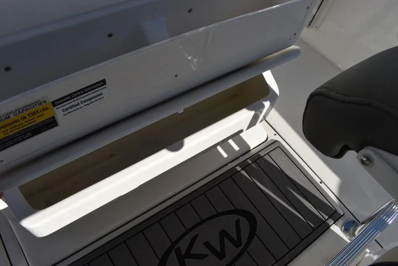 Slide: The Image of Key West 244 CC 2025 boat interior with storage compartment and KW logo mat. - 39