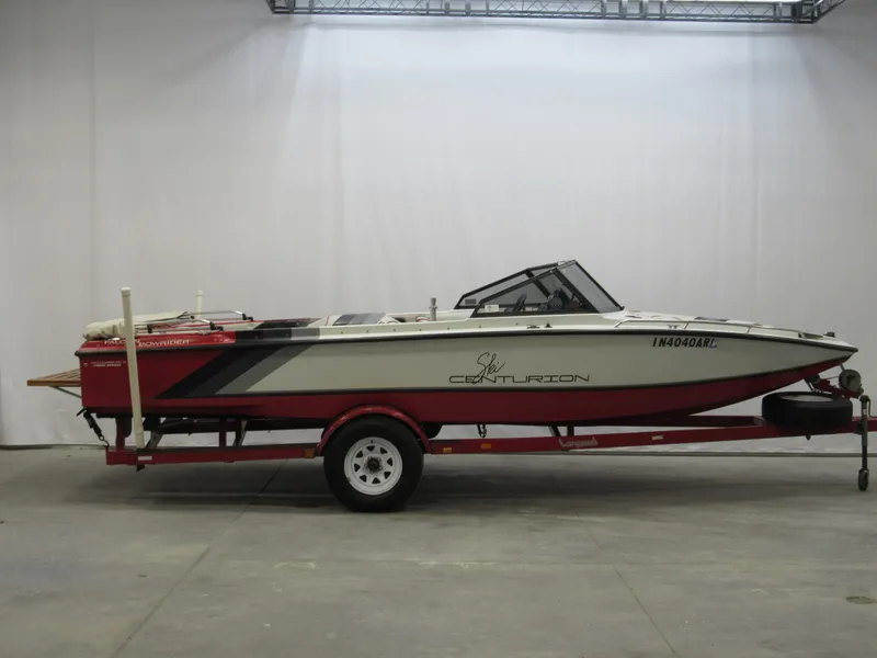 Slide: The Image of 1990 Centurion Falcon BR boat on red trailer in indoor setting. - 4