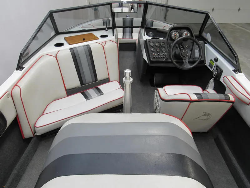 Slide: The Image of 1990 Centurion Falcon BR boat interior with white and gray seating, steering wheel, and dashboard. - 7