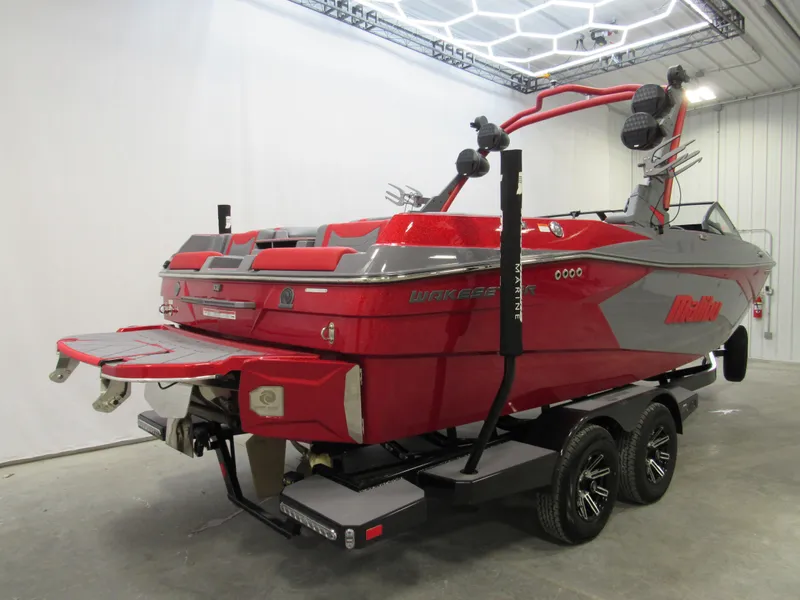 Slide: The Image of 2025 Malibu Wakesetter 23 LSV boat in red and gray on a trailer. - 2