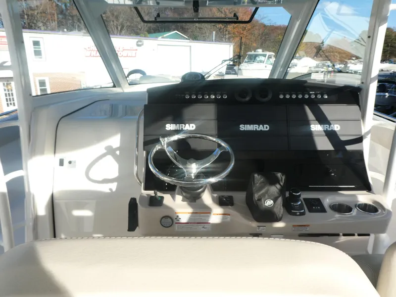Slide: The Image of 2025 Boston Whaler 420 Outrage helm with Simrad electronics and steering wheel. - 12