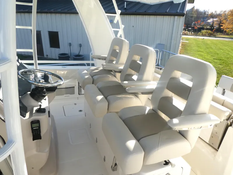 Slide: The Image of 2025 Boston Whaler 420 Outrage helm with three cushioned seats and steering wheel. - 14