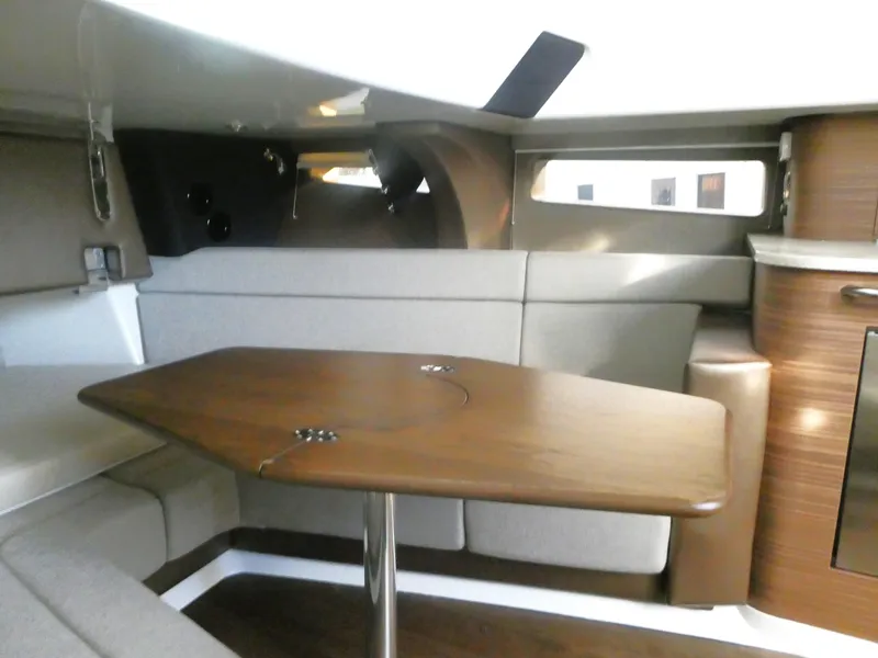 Slide: The Image of Luxurious interior of 2025 Boston Whaler 420 Outrage with elegant wood table and seating. - 18