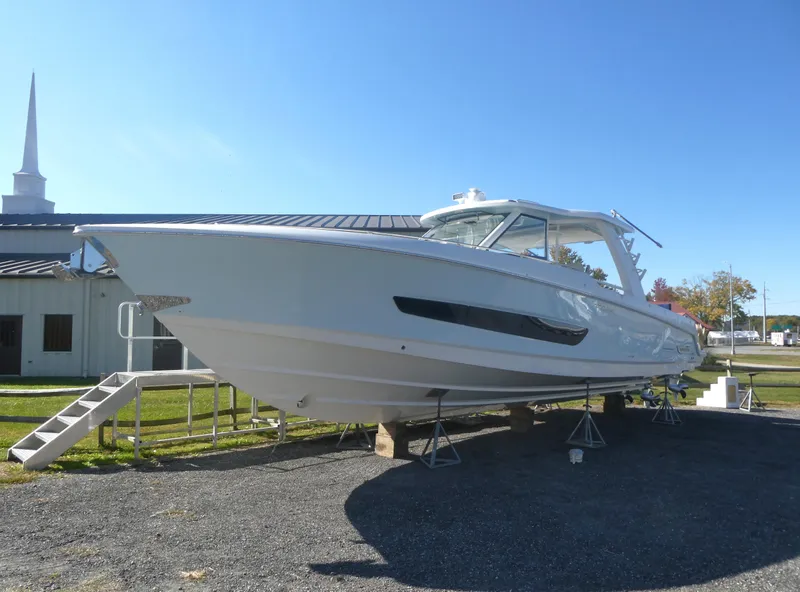 Slide: The Image of 2025 Boston Whaler 420 Outrage boat on display outdoors. - 2