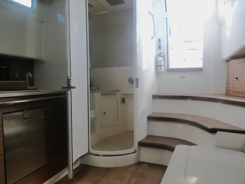 Slide: The Image of Interior of 2025 Boston Whaler 420 Outrage, featuring modern kitchen and bathroom amenities. - 22