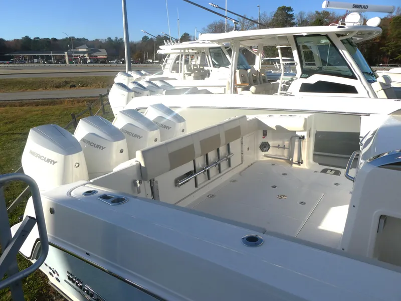Slide: The Image of 2025 Boston Whaler 420 Outrage boat with Mercury engines, docked outdoors. - 6