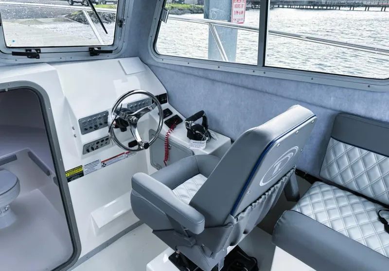Slide: The Image of Interior of 2025 Defiance Admiral 260 EX boat with steering wheel and seating. - 15