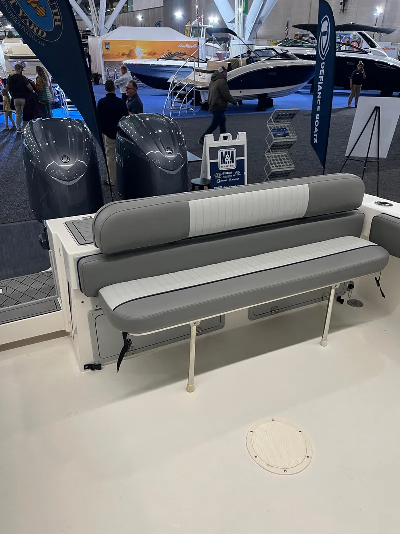 Slide: The Image of Defiance Admiral 260 EX 2025 boat interior with seating and dual engines at a boat show. - 3