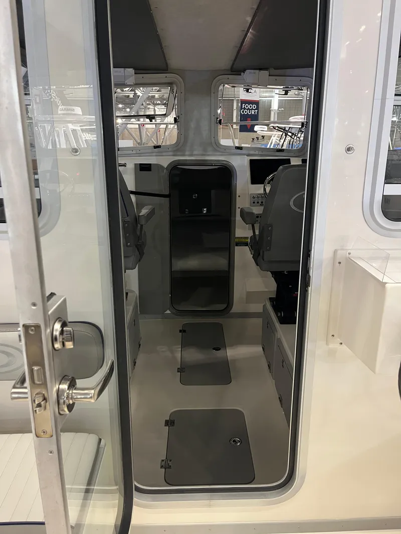 Slide: The Image of Interior view of 2025 Defiance Admiral 260 EX boat cabin with seating and controls. - 6
