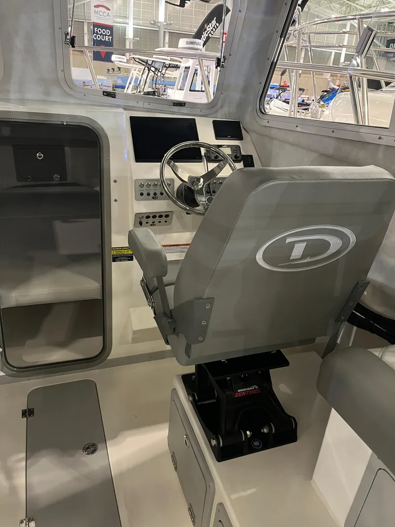 Slide: The Image of Interior of 2025 Defiance Admiral 260 EX boat, featuring helm and seating area. - 7