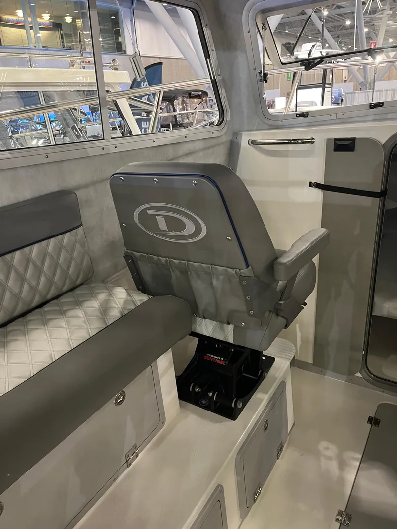 Slide: The Image of Interior of 2025 Defiance Admiral 260 EX boat with gray seating and storage compartments. - 8