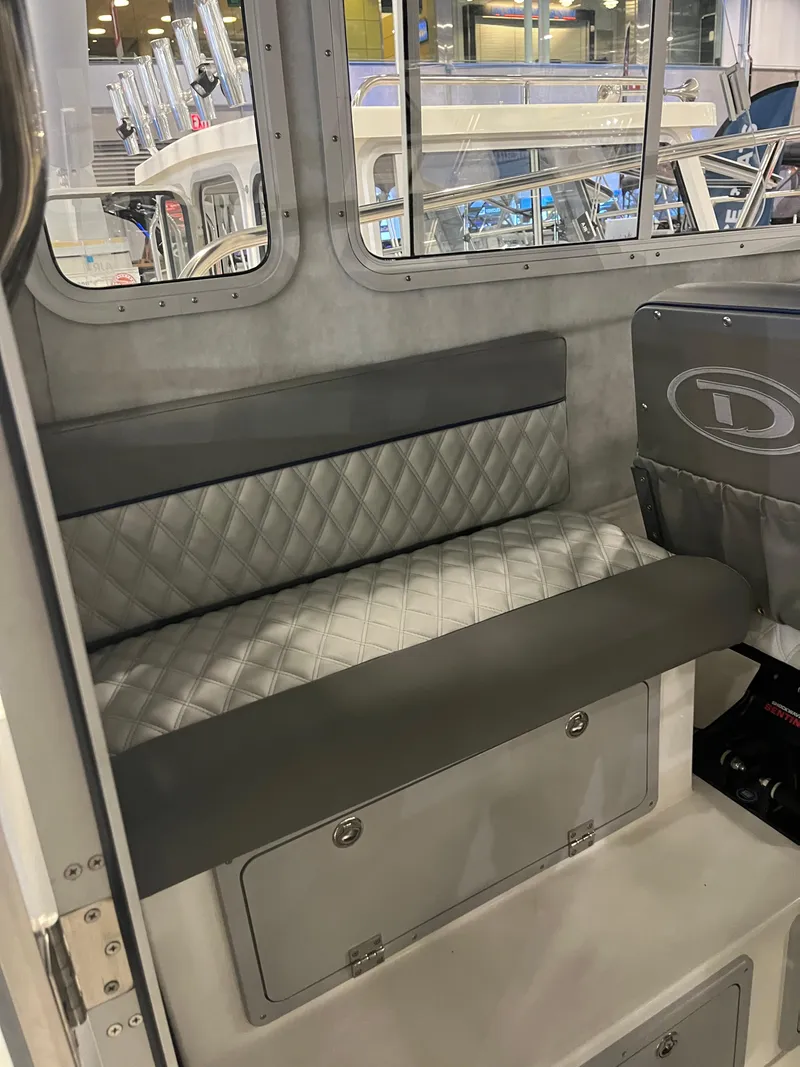 Slide: The Image of Interior seating of 2025 Defiance Admiral 260 EX boat, featuring quilted upholstery. - 9
