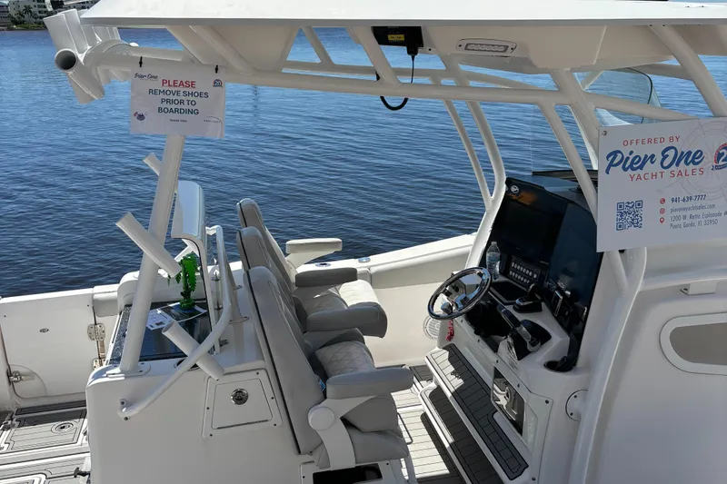 Slide: The Image of 2020 Sea Fox Commander 328 boat interior with steering wheel and seating by the water. - 7