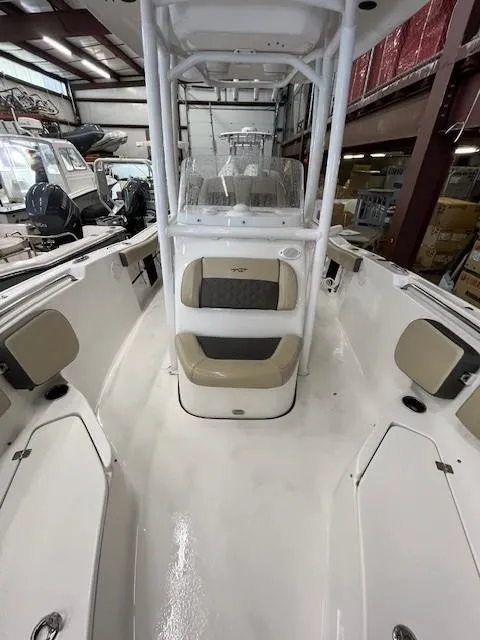 Slide: The Image of 2021 Tidewater 220 CC Adventure boat interior with seating and console in a showroom. - 10