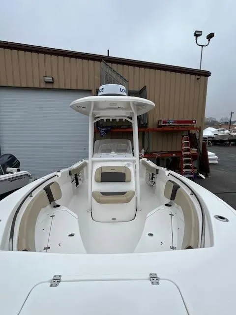 Slide: The Image of 2021 Tidewater 220 CC Adventure boat, docked near a warehouse. - 19