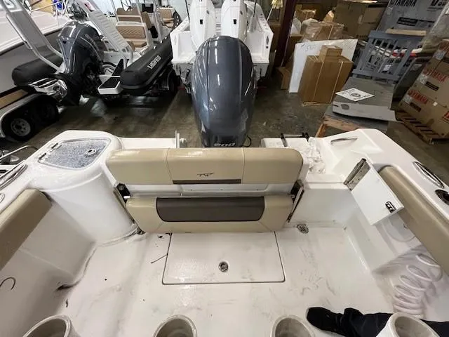 Slide: The Image of 2021 Tidewater 220 CC Adventure boat interior with seating and motor in a showroom. - 8