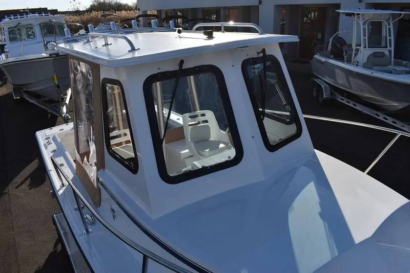 Slide: The Image of 2025 Steiger Craft 21 Peconic boat with enclosed cabin, docked outdoors. - 19