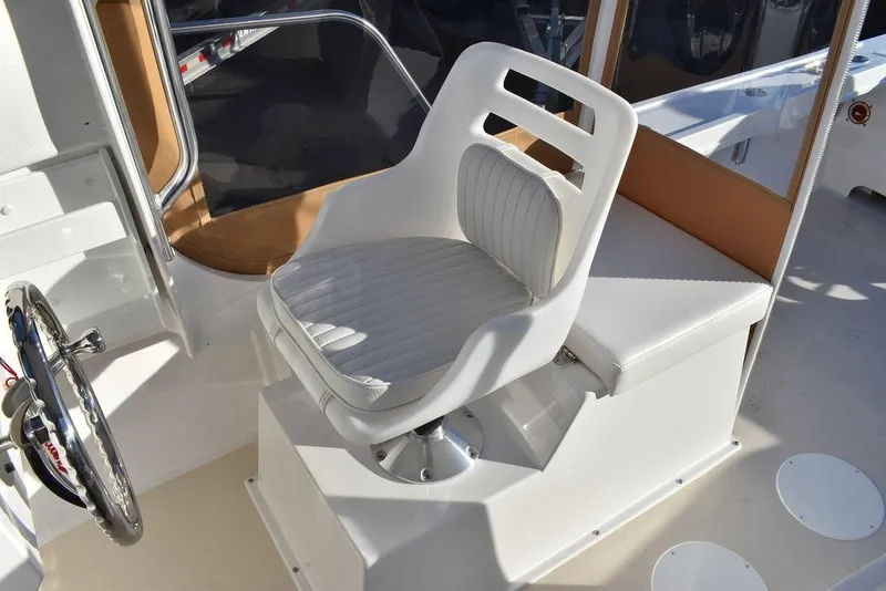 Slide: The Image of 2025 Steiger Craft 21 Peconic boat interior with white captain's chair and steering wheel. - 39