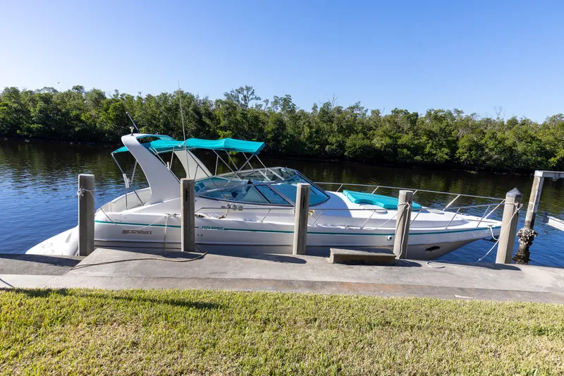 Slide: The Image of 1995 Cruisers Esprit 3570 boat docked by a serene riverbank. - 1