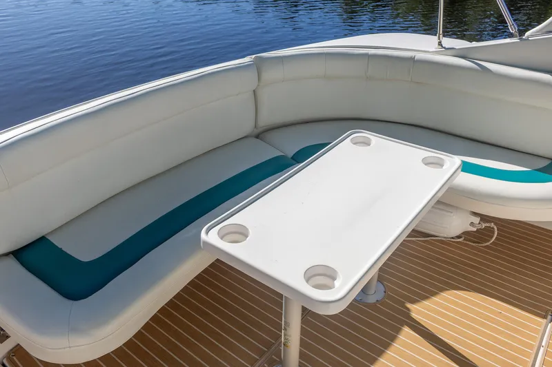 Slide: The Image of 1995 Cruisers Esprit 3570 boat interior with white seating and table on wooden deck. - 23