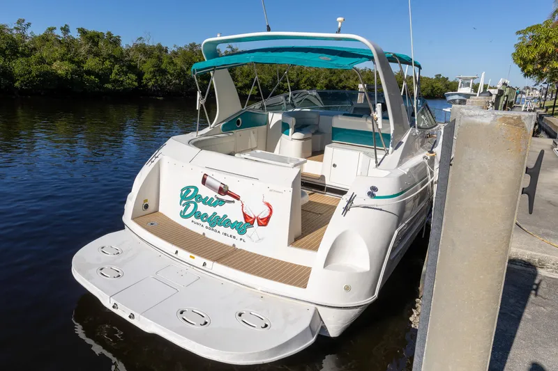 Slide: The Image of 1995 Cruisers Esprit 3570 boat docked on a sunny day, featuring teal accents. - 3