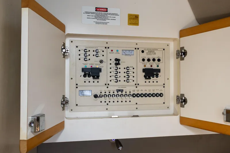 Slide: The Image of Electrical panel inside 1995 Cruisers Esprit 3570 boat, with open cabinet doors. - 37
