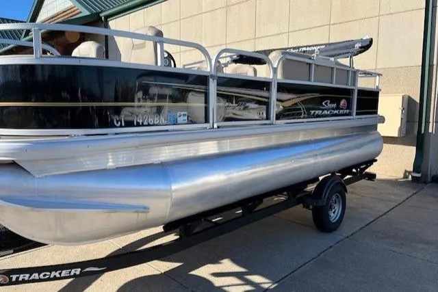 Slide: The Image of 2022 Sun Tracker Bass Buggy 18 DLX pontoon boat on trailer, parked outdoors. - 3