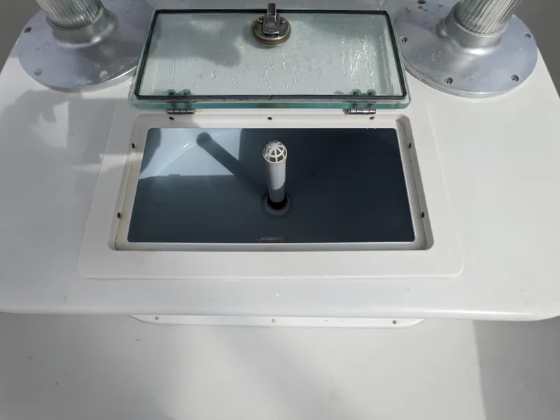 Slide: The Image of Parker 2500 SE Center Console 2019 boat livewell with open lid and rod holders. - 10