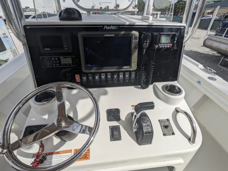 Slide: The Image of 2019 Parker 2500 SE Center Console boat dashboard with steering wheel and navigation equipment. - 12