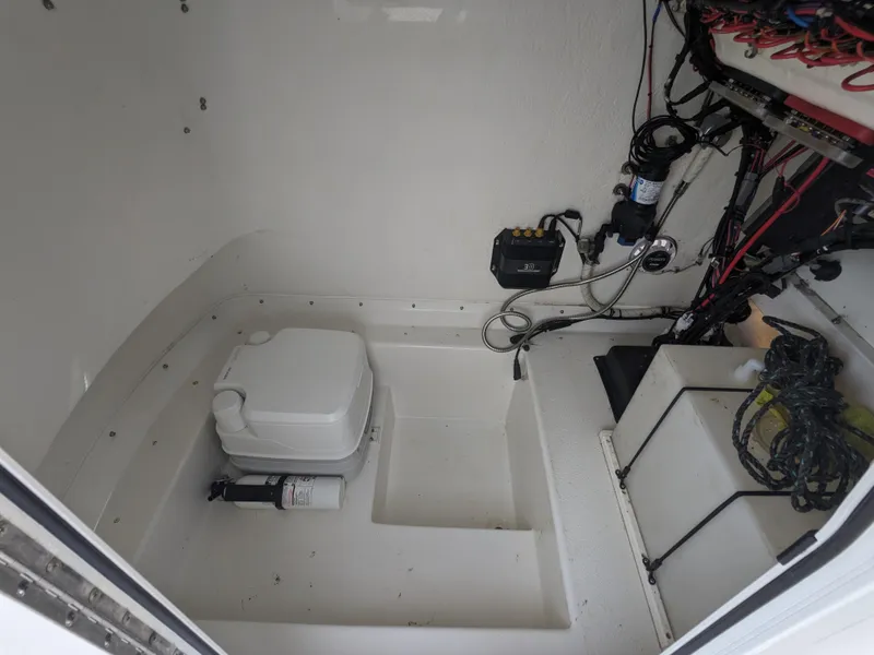 Slide: The Image of 2019 Parker 2500 SE Center Console interior with portable toilet and wiring. - 14