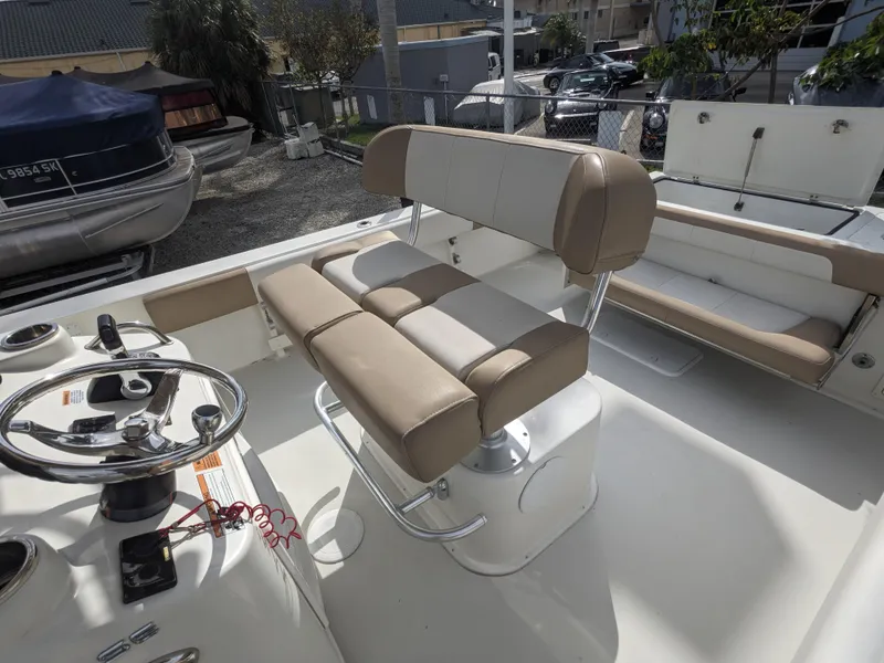 Slide: The Image of 2019 Parker 2500 SE Center Console boat interior with beige seating and steering wheel. - 7