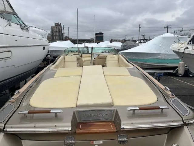 Slide: The Image of 2014 Chris-Craft Launch 32 boat with beige seating and wood flooring in a marina. - 4