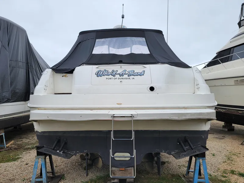 Slide: The Image of Sea Ray 460 Sundancer 2000 boat on stands, rear view, covered, in storage. - 11