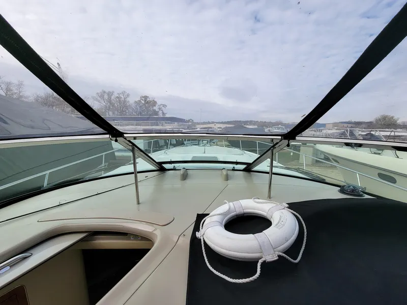 Slide: The Image of 2000 Sea Ray 460 Sundancer yacht deck with life preserver, under cloudy sky. - 16