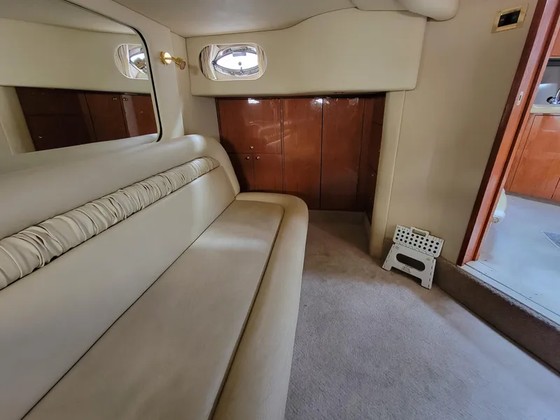 Slide: The Image of Interior of 2000 Sea Ray 460 Sundancer yacht with beige seating and wooden cabinets. - 26