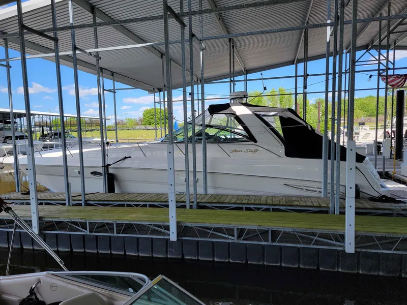 Slide: The Image of 2000 Sea Ray 460 Sundancer docked in a marina under a metal canopy. - 3