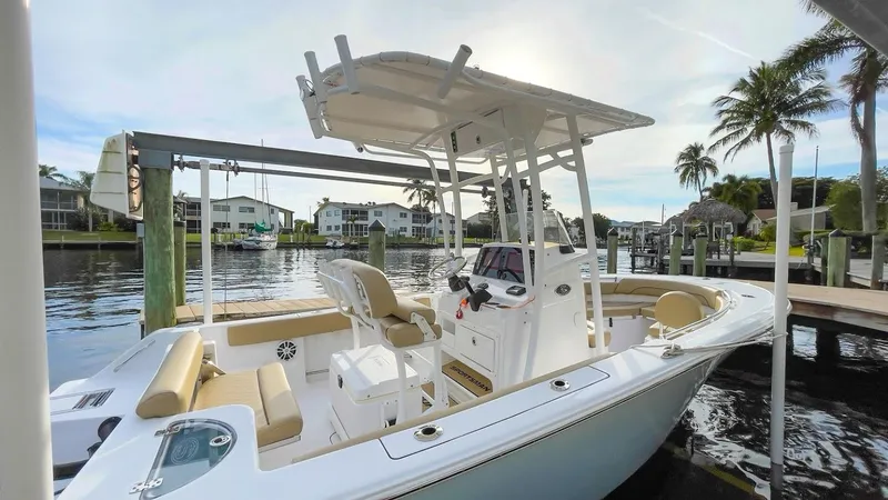 Slide: The Image of 2018 Sportsman Open 212 boat docked in a scenic waterfront setting. - 2