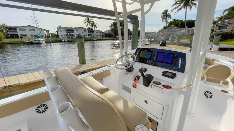 Slide: The Image of 2018 Sportsman Open 212 boat interior with console, docked by waterfront homes. - 8