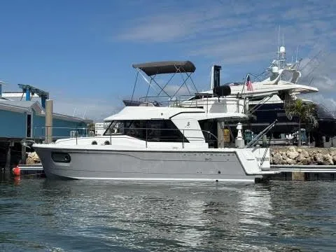 Slide: The Image of 2016 Beneteau Swift Trawler 30 docked at marina under clear sky. - 0